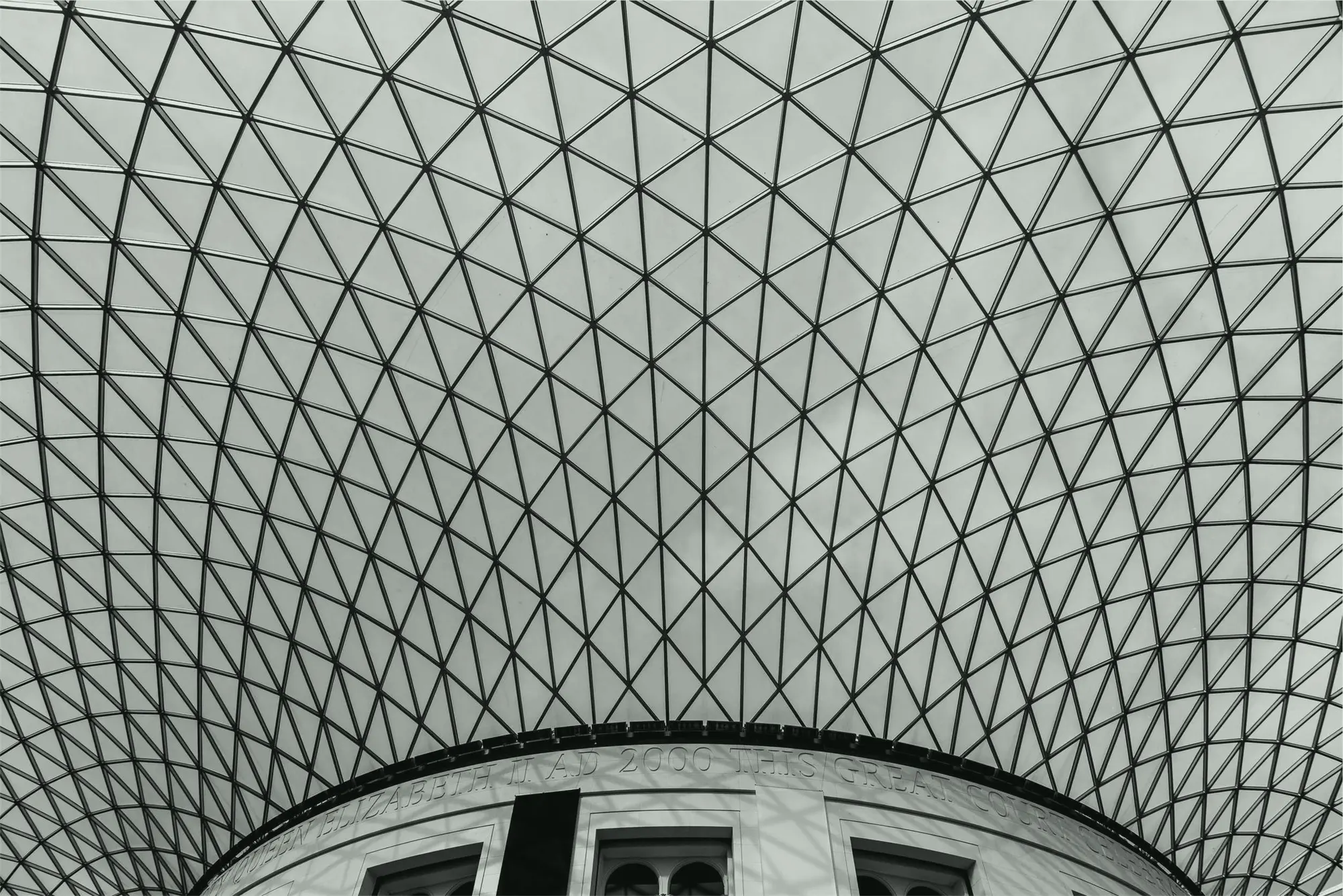 A glass and steel lattice roof spanning a circular courtyard